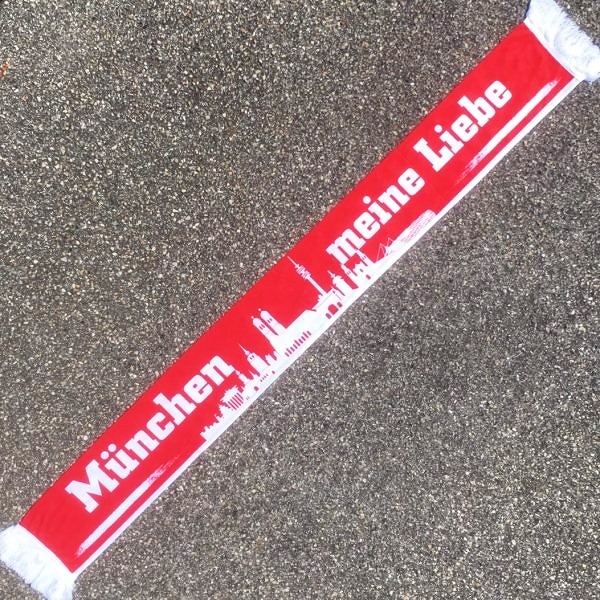 Schal "München meine Liebe" Der bedruckte Poly-Schal Schal "München meine Liebe" war bisher nur an unserem Fanshop im U-Bahnhof Fröttmaning bei Heimspielen des FC Bayern München erhältlich. Ab jetzt gibt es diesen Schal für Euch auch in unserem Online-Shop. Wenn Ihr diesen Schal bestellen solltet, haltet ihn (sowie auch Eure anderen roten Fanartikel) immer in Ehren! Dieser Schal ist mit viel Leidenschaft und Herzblut von unserem Fan-Point Team entworfen worden und hält von seiner Qualität her ewig. Einige von uns sind schon seit 1972 oder länger dabei, andere noch nicht so lange, oder manche erst relativ neu, aber alle sind rot bis unters Dach. Die ersten eigenen Fanartikel stellten wir damals im Olympiastadion her und 1994 haben wir dann unseren ersten Verkaufsstand am Oly gehabt. Für uns gilt es also wirklich “rot und weiss – ein Leben lang”. Wir versuchen ständig zusammen mit unseren Produzenten die Qualität und die Designs zu verbessern. Das herstellen von rot-weissen Fanartikeln für uns nicht einfach ein Beruf, “nein” es ist eine Berufung und unsere größte Freude ist, wenn sie Euch gefallen. Material: 100% Polyester Größe: 140 x 16 cm